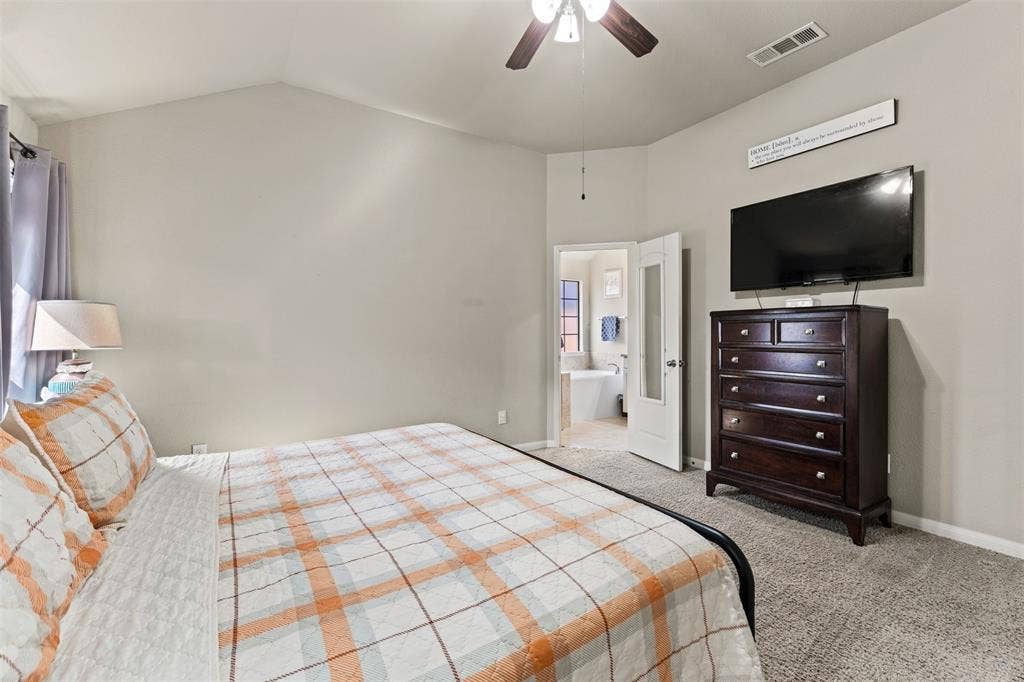 10313 Condor Loop, Waco, TX 76708 Vaulted ceiling with a ceiling fan, carpeted flooring, and an en-suite bathroom access with a soaking tub