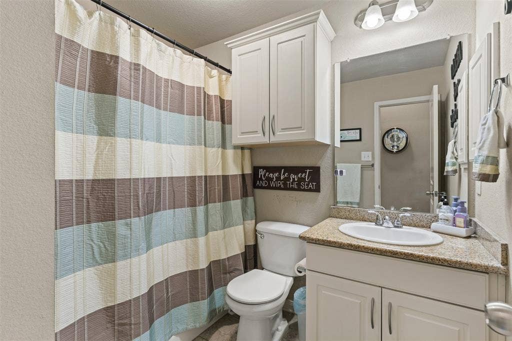 10313 Condor Loop, Waco, TX 76708 Vanity with a granite-style countertop, white cabinetry, and a drop-in sink