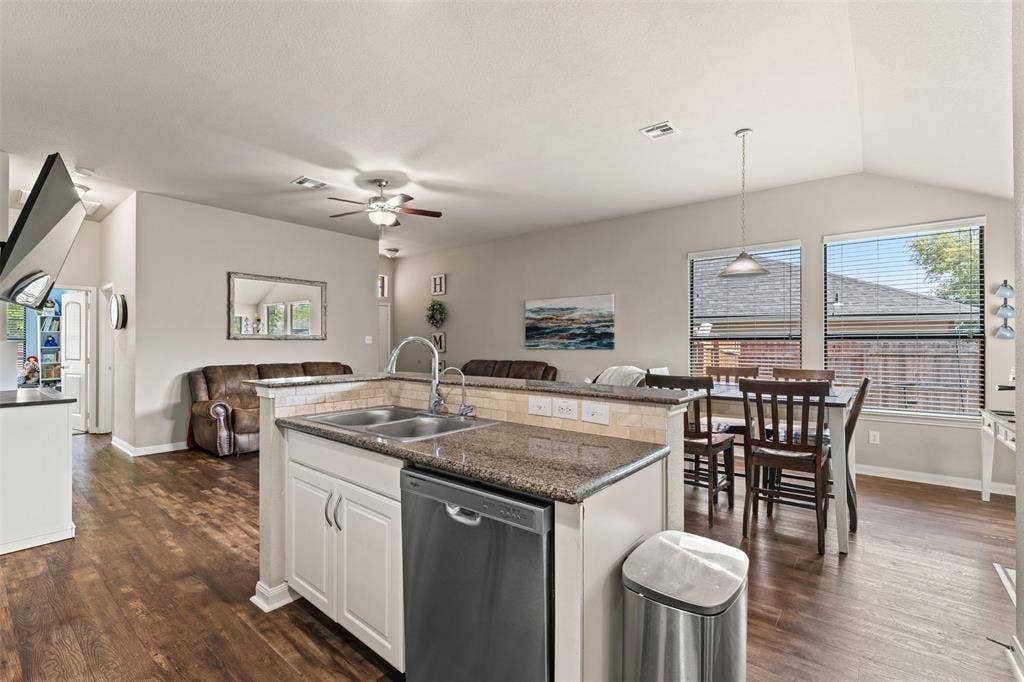 10313 Condor Loop, Waco, TX 76708 Kitchen island with double basin sink, stainless steel dishwasher, and granite countertop