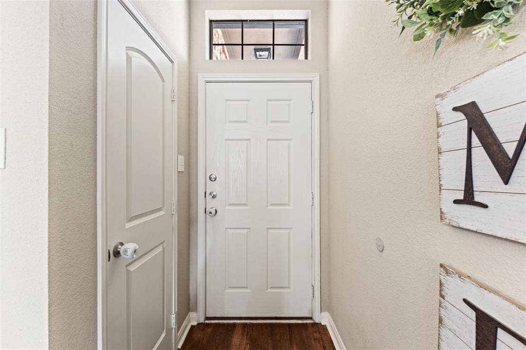 10313 Condor Loop, Waco, TX 76708 Wood-finish flooring, white paneled door, and a transom window above the entry door
