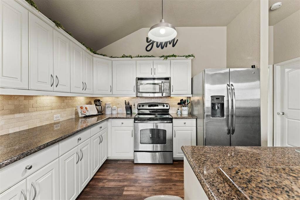 10313 Condor Loop, Waco, TX 76708 Kitchen featuring white cabinetry, wood-finish flooring, granite countertops, tile backsplash, and stainless steel appliances