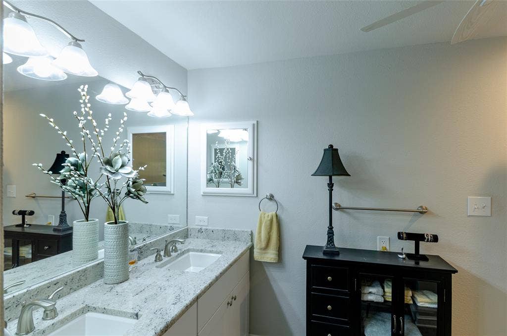 3613 Windmill Hill Street, Waco, TX 76710 Dual vanity with integrated sinks, light-toned countertop, large wall-mounted mirror, and overhead vanity lighting