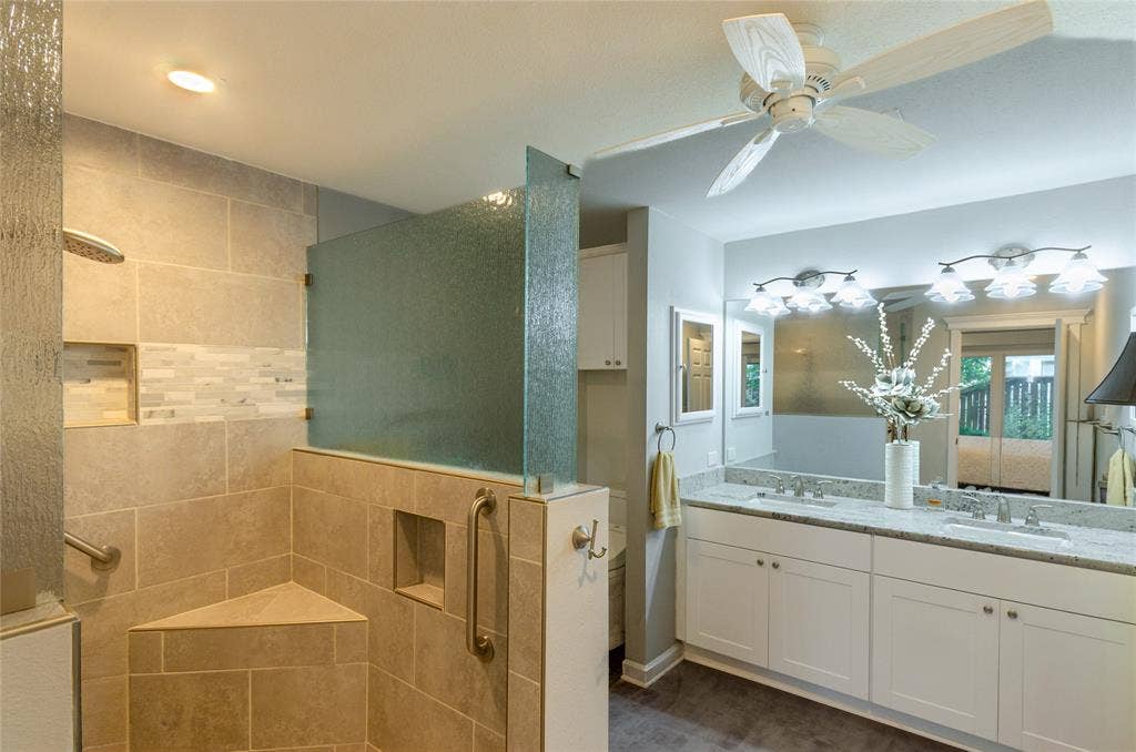 3613 Windmill Hill Street, Waco, TX 76710 Tiled walk-in shower with a built-in bench, dual shower heads, and an accent tile band