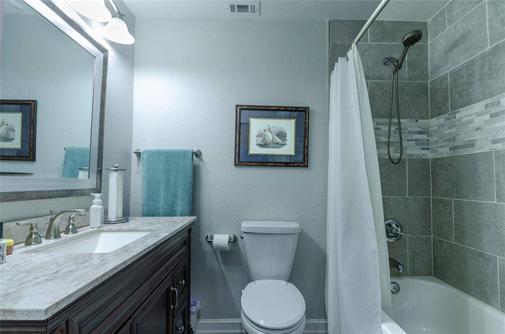 3613 Windmill Hill Street, Waco, TX 76710 Bathroom featuring a dark wood-finish vanity with a light countertop, undermount sink, and brushed nickel fixtures