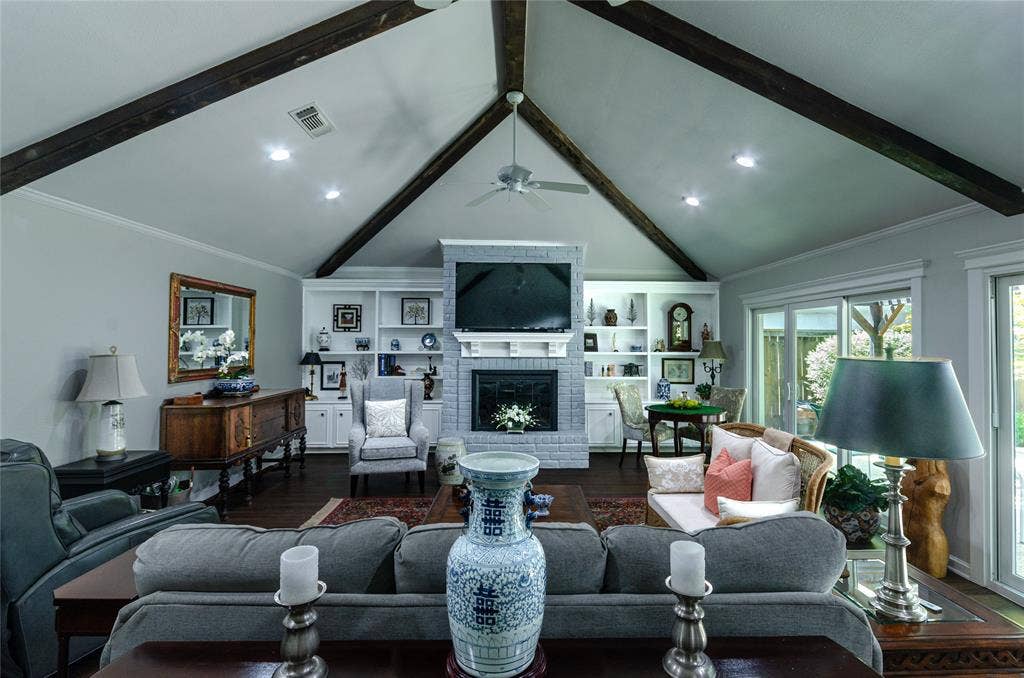 3613 Windmill Hill Street, Waco, TX 76710 Vaulted ceiling with exposed wood beams, built-in shelving, brick fireplace with mantel, and sliding glass doors
