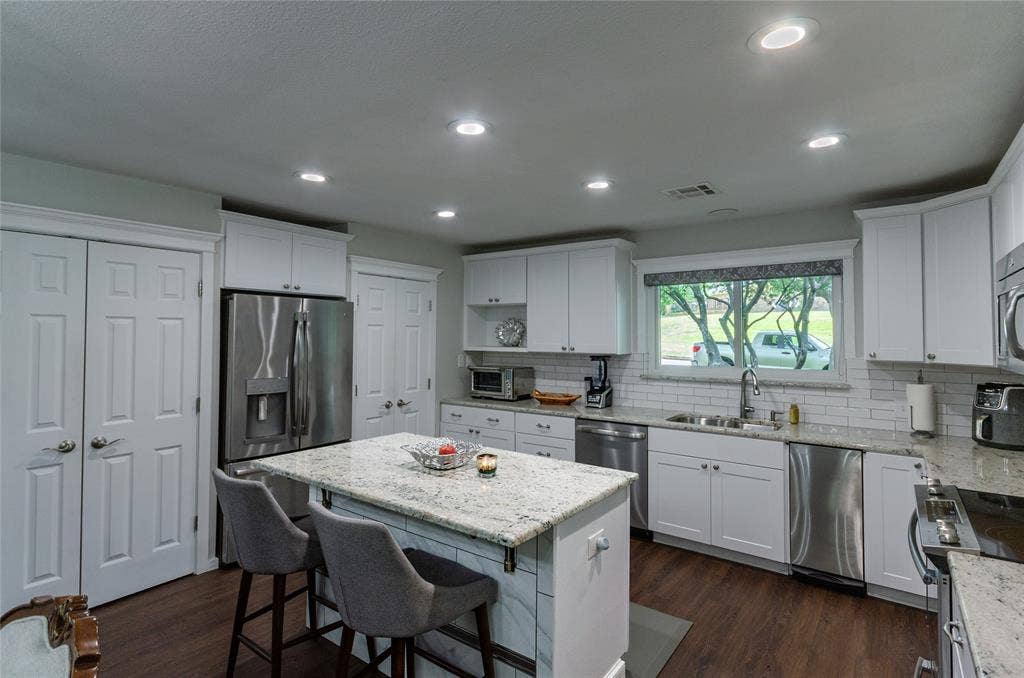 3613 Windmill Hill Street, Waco, TX 76710 Kitchen featuring white cabinetry, granite countertops, stainless steel appliances, wood-finish flooring, and recessed lighting