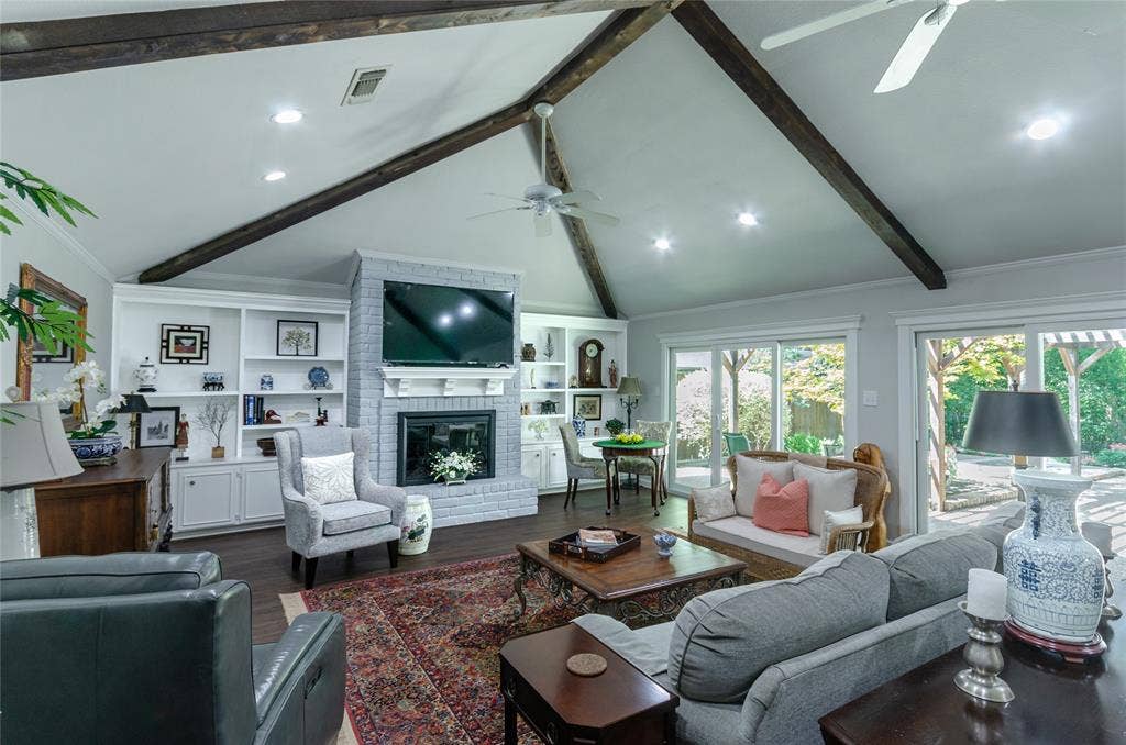 3613 Windmill Hill Street, Waco, TX 76710 Vaulted ceiling with exposed wood beams, built-in shelving, brick fireplace, wood-finish flooring, and sliding glass doors