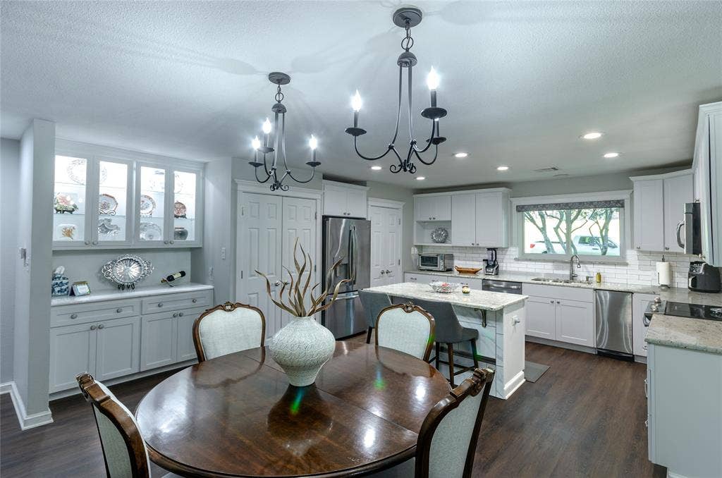 3613 Windmill Hill Street, Waco, TX 76710 Kitchen with white cabinetry, stainless steel appliances, a center island with seating, and wood-finish flooring
