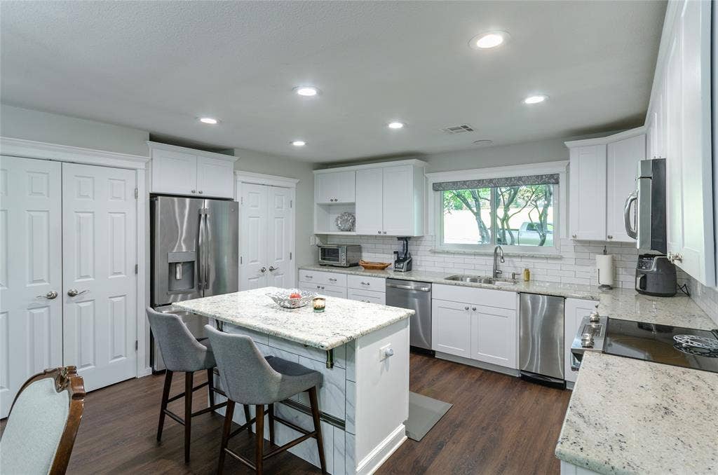 3613 Windmill Hill Street, Waco, TX 76710 Kitchen featuring an island with a light-toned countertop, dark wood-finish flooring, white cabinetry, stainless steel appliances, and recessed lighting