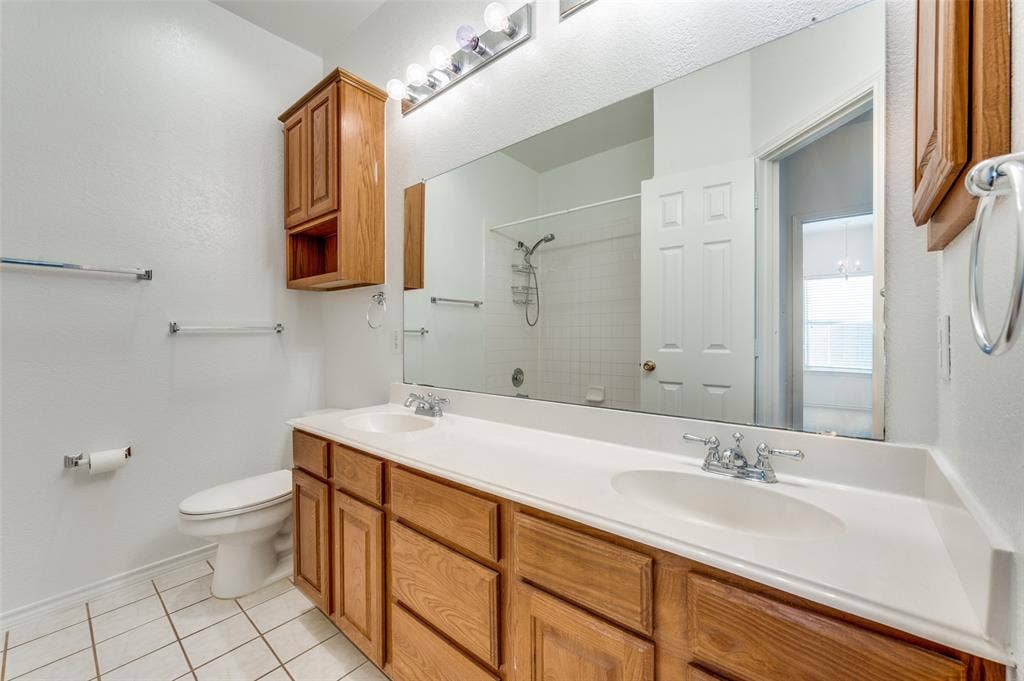 The 2nd & 3rd bedrooms share the bathroom. Double vanity with integrated sinks and chrome fixtures.