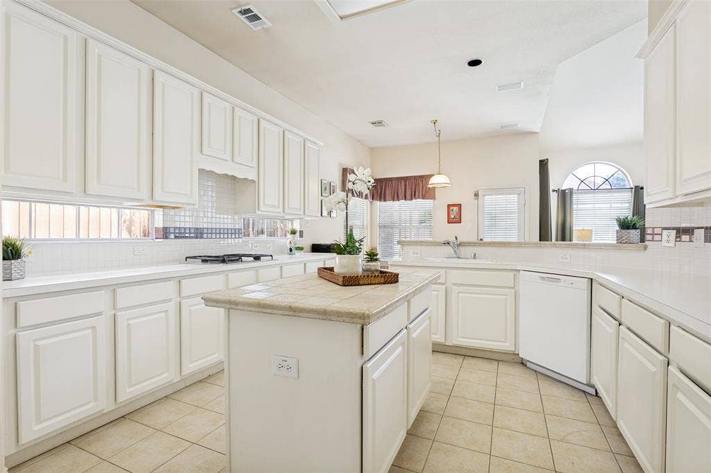 4308 Cedar Valley Drive, Plano, TX 75024 Kitchen is large and bright with a prep island and gas cooktop.