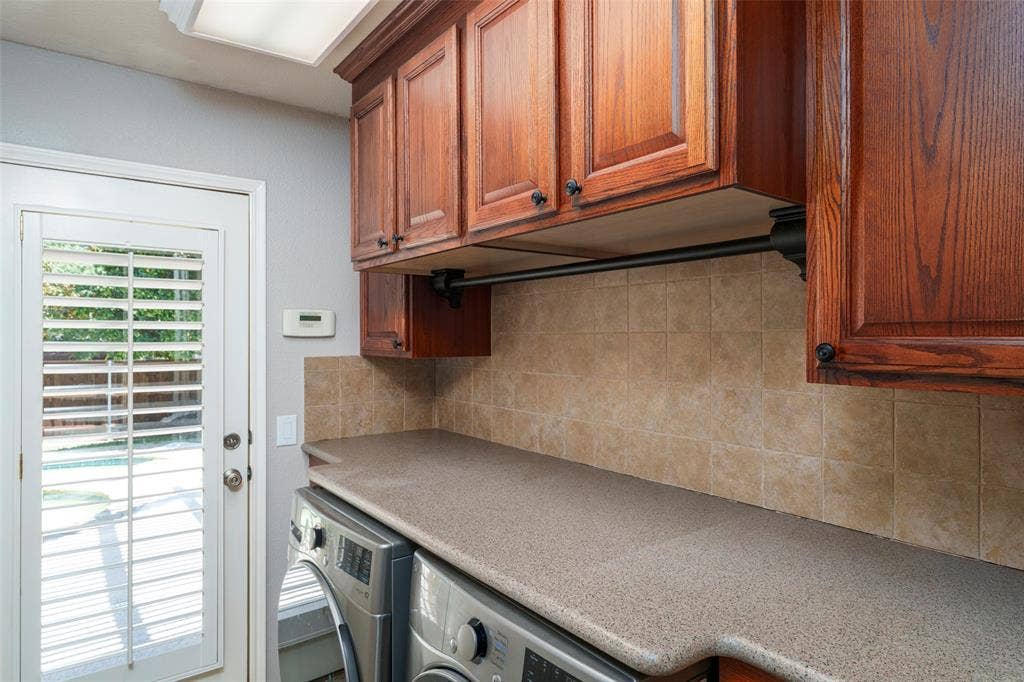 1620 Babbling Brook Drive, Grand Prairie, TX 75050 Wood-finish cabinetry, solid surface countertop, tiled backsplash, and a white paneled door