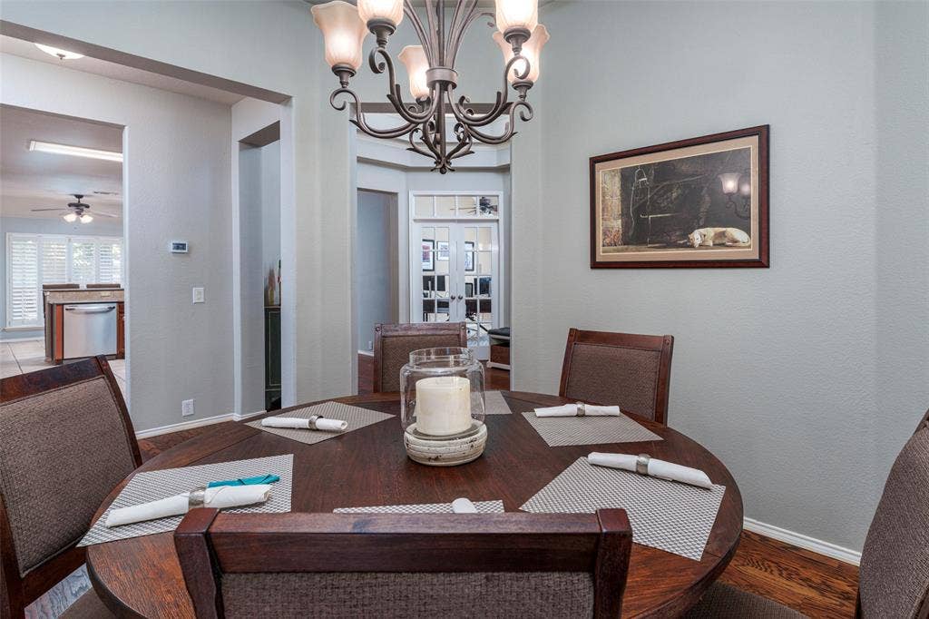 1620 Babbling Brook Drive, Grand Prairie, TX 75050 Dedicated dining area featuring a dark wood-finish round table and a wrought iron chandelier with frosted glass shades
