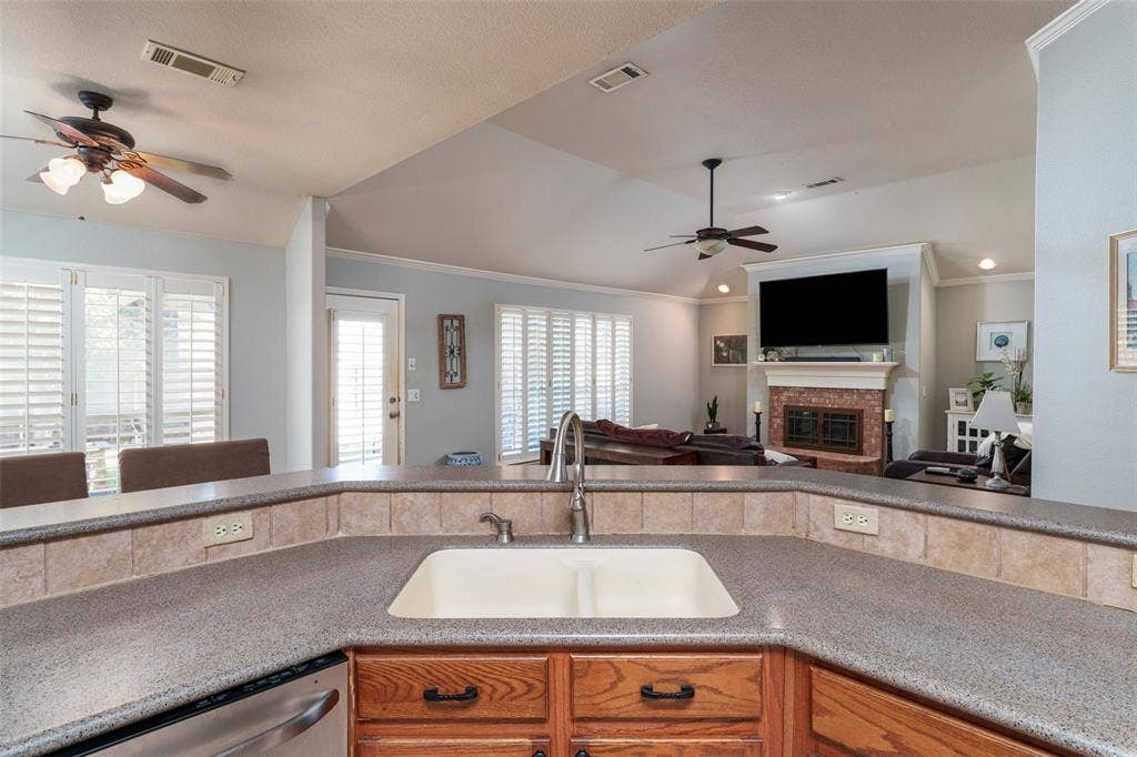 1620 Babbling Brook Drive, Grand Prairie, TX 75050 Kitchen featuring a double basin sink, durable countertop, and wood cabinetry