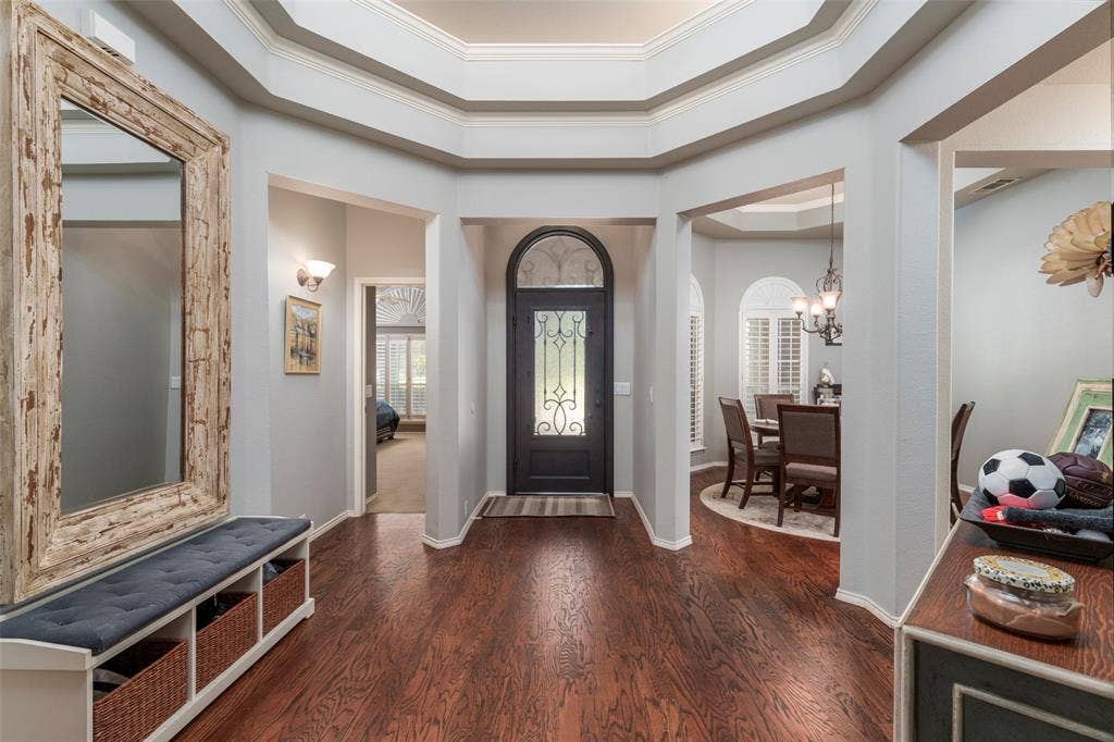 1620 Babbling Brook Drive, Grand Prairie, TX 75050 Hardwood-style flooring throughout, an arched front door with decorative glass, and a coffered ceiling detail