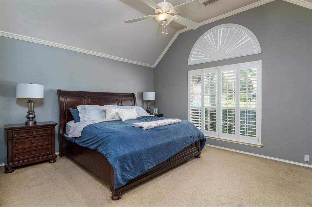 1620 Babbling Brook Drive, Grand Prairie, TX 75050 Vaulted ceiling with a ceiling fan, crown molding, arched transom window, and plantation shutters