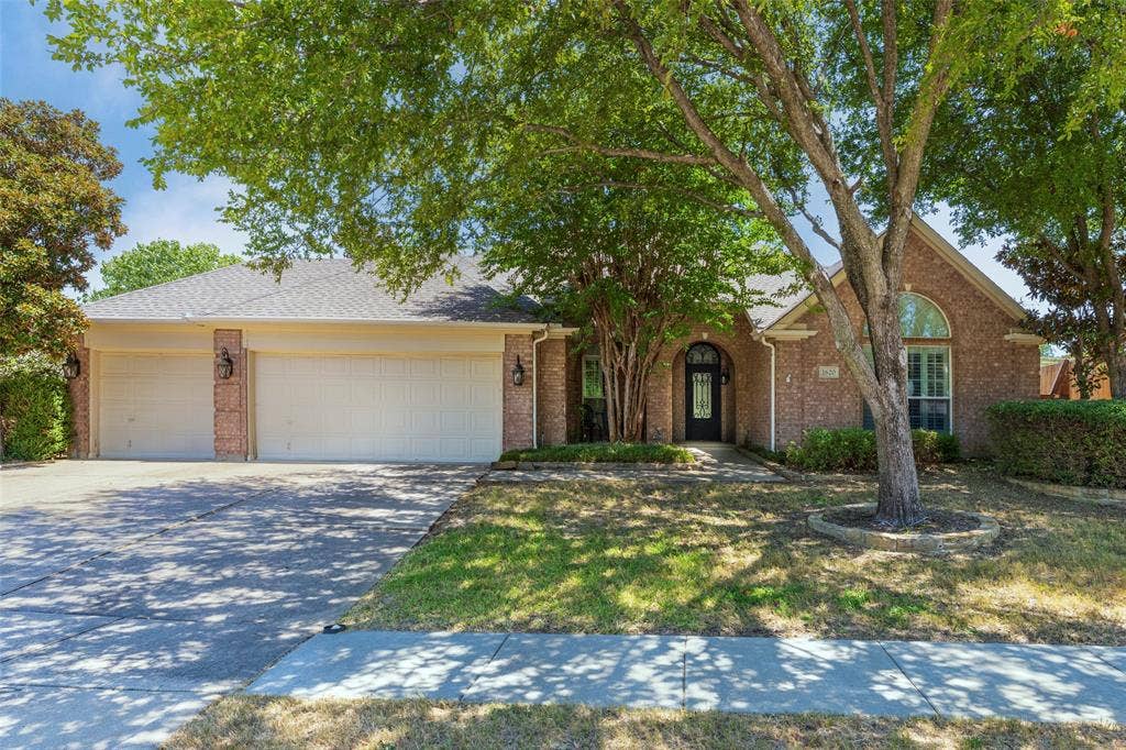 1620 Babbling Brook Drive, Grand Prairie, TX 75050 Brick exterior with arched entry, dual garage doors, and an arched window