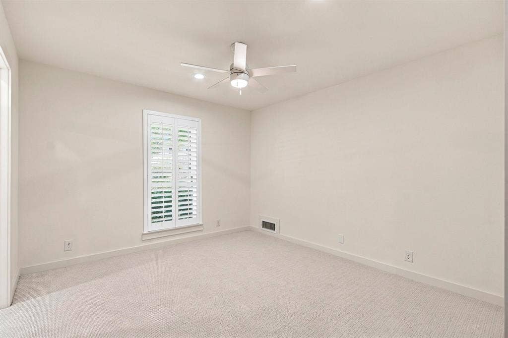 1409 Navaho Trail, Richardson, TX 75080 Window with white plantation shutters, ceiling fan with integrated lighting, recessed lighting, and carpeted flooring