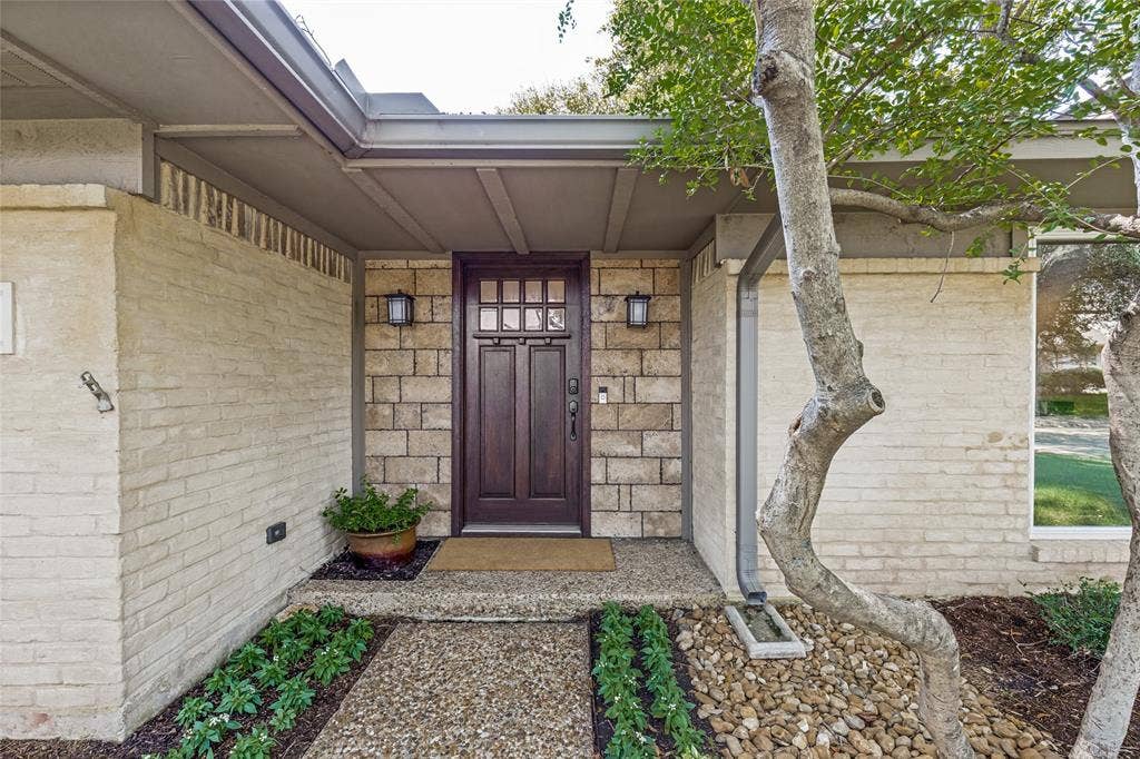 Rows of flowers lead to the covered entry.