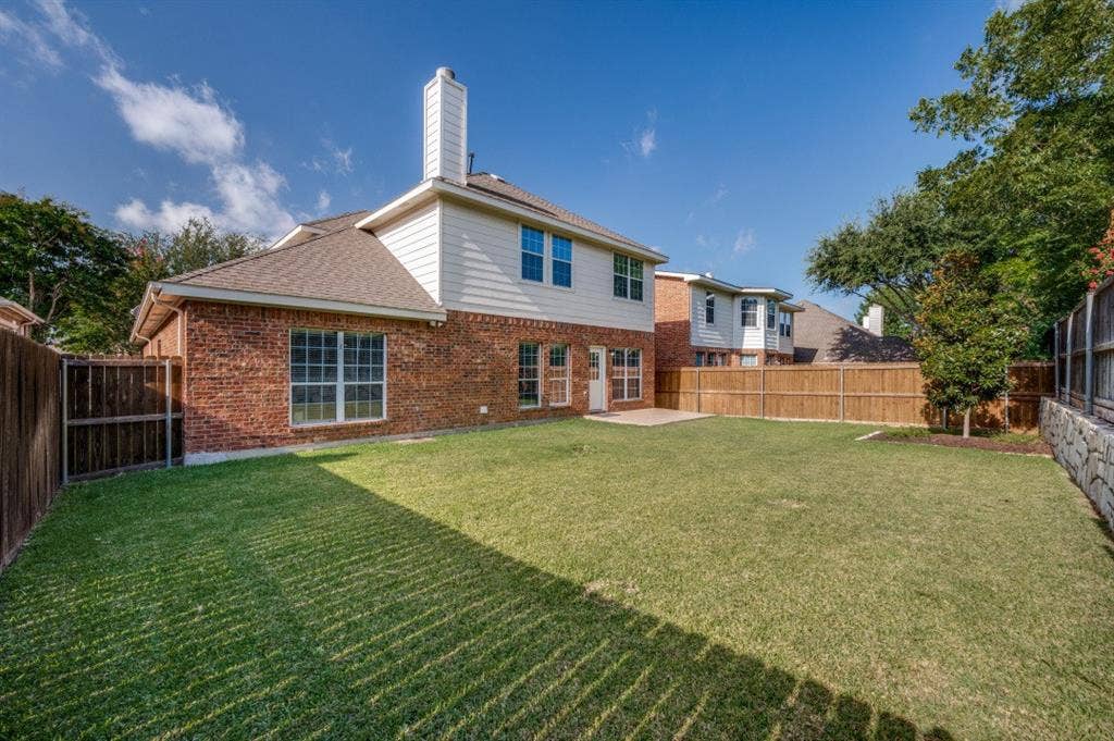 7900 White Stallion Trail, McKinney, TX 75070 Expansive backyard with a manicured lawn, brick exterior, and a privacy fence