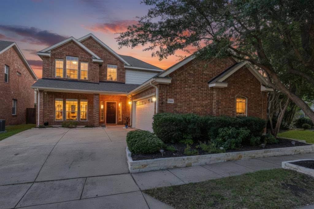 7900 White Stallion Trail, McKinney, TX 75070 Brick exterior with white trim, multi-pane windows, attached garage, concrete driveway, and landscaped front beds