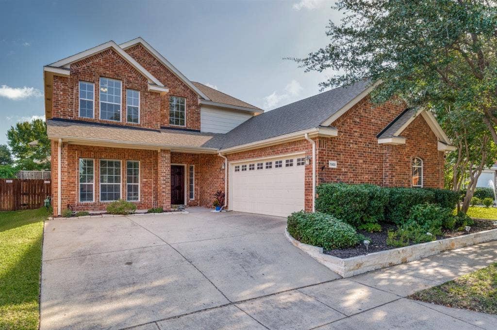 7900 White Stallion Trail, McKinney, TX 75070 Brick exterior with multiple windows and an attached garage