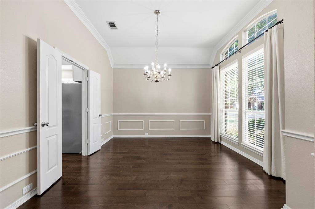 2910 Live Oak Drive, Rowlett, TX 75088 Vaulted ceiling, dark wood-finish flooring, decorative wall molding, arched transom windows, and a multi-arm chandelier