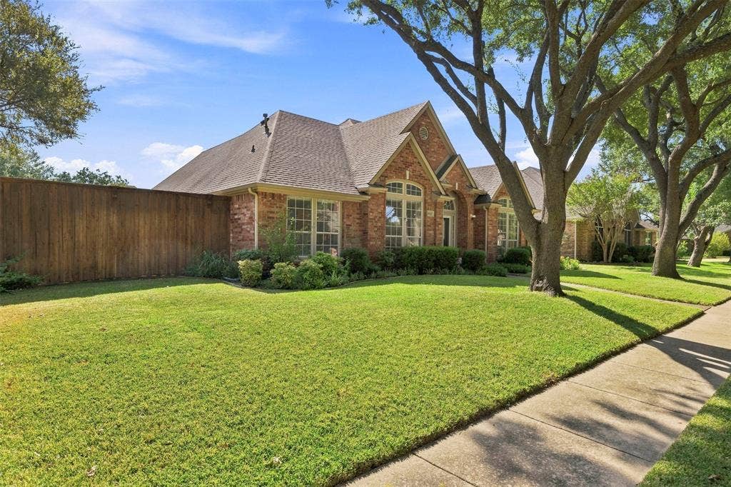 2910 Live Oak Drive, Rowlett, TX 75088 Brick exterior with a gabled roof and a wooden privacy fence