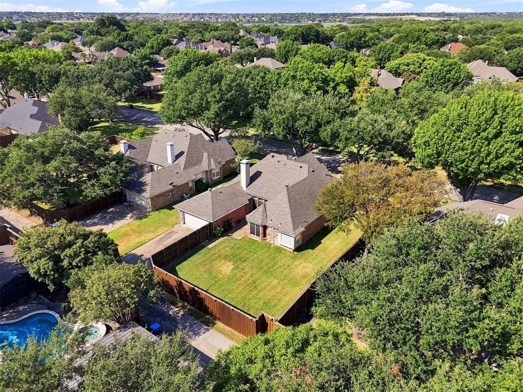 2910 Live Oak Drive, Rowlett, TX 75088 Expansive residential property featuring a large landscaped backyard, mature trees, and privacy fencing