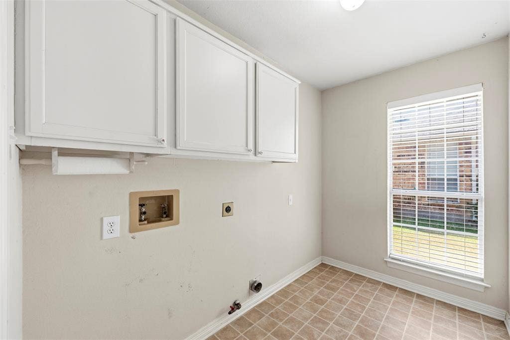 2910 Live Oak Drive, Rowlett, TX 75088 Upper cabinetry, tiled flooring, window with blinds, and white baseboards