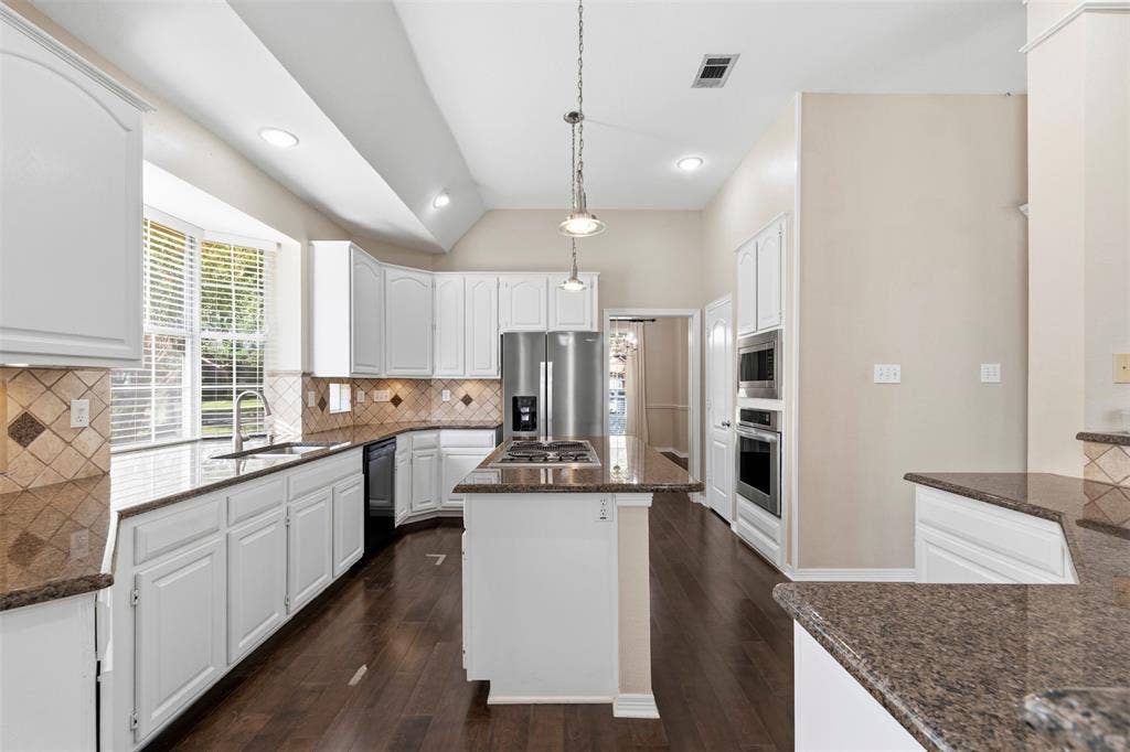2910 Live Oak Drive, Rowlett, TX 75088 Kitchen featuring white cabinetry, dark wood-finish flooring, granite countertops, and stainless steel built-in appliances