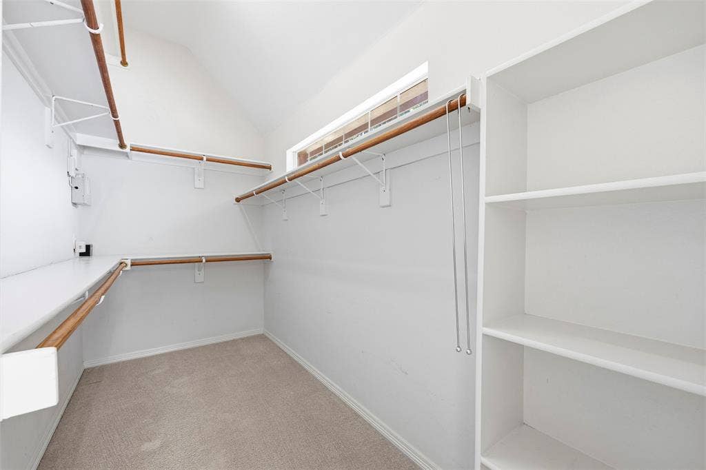 2910 Live Oak Drive, Rowlett, TX 75088 Expansive closet featuring integrated shelving, multiple wood-finish hanging rods, and a high window for natural light