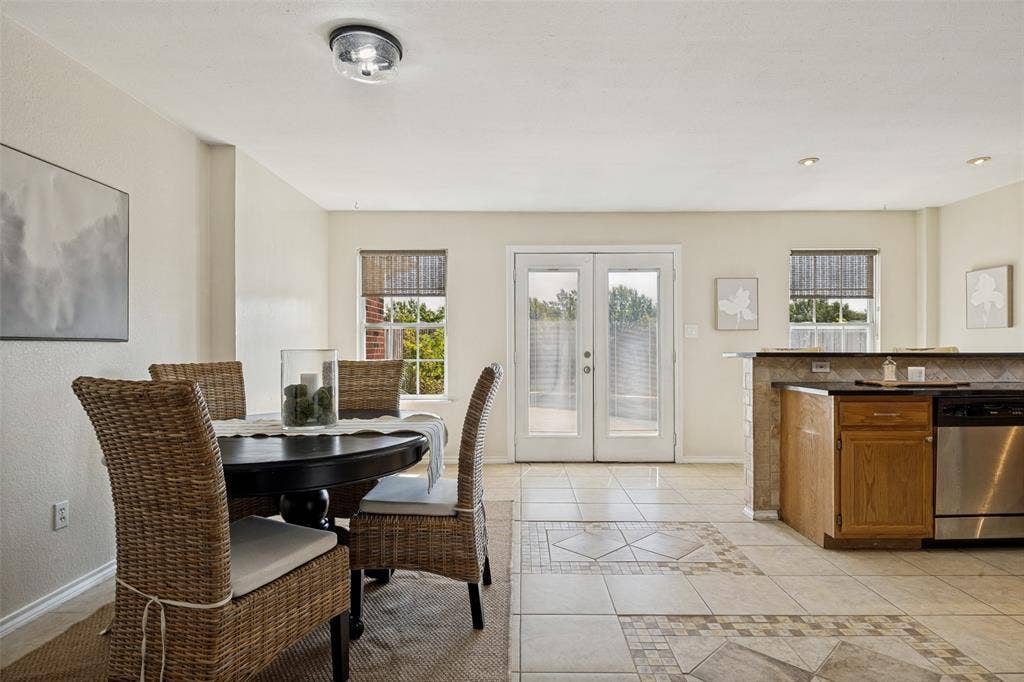 2922 Andrea Lane, Garland, TX 75040 Ceramic tile flooring, white walls, double French doors, light wood cabinetry, and stainless steel appliances