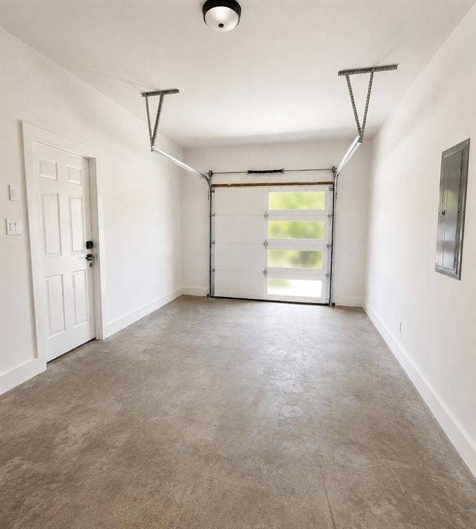 2542 Hooper Street, Dallas, TX 75215 Modern garage door with frosted glass panels, concrete flooring, and flush-mount ceiling light