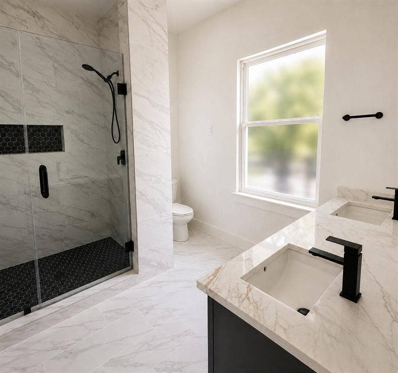 2542 Hooper Street, Dallas, TX 75215 Dual vanity with undermount sinks and matte black fixtures, stone finish countertops, frameless glass shower enclosure with matte black fixtures, integrated shower niche, and hexagonal tile shower floor