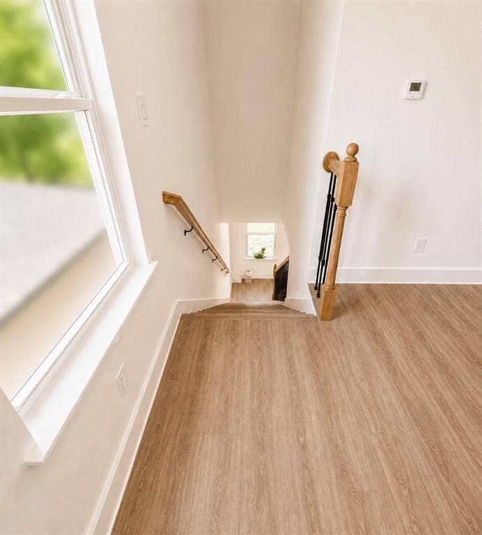 2542 Hooper Street, Dallas, TX 75215 Wood-finish flooring throughout, bright white walls, white window trim, and a natural wood handrail with black balusters