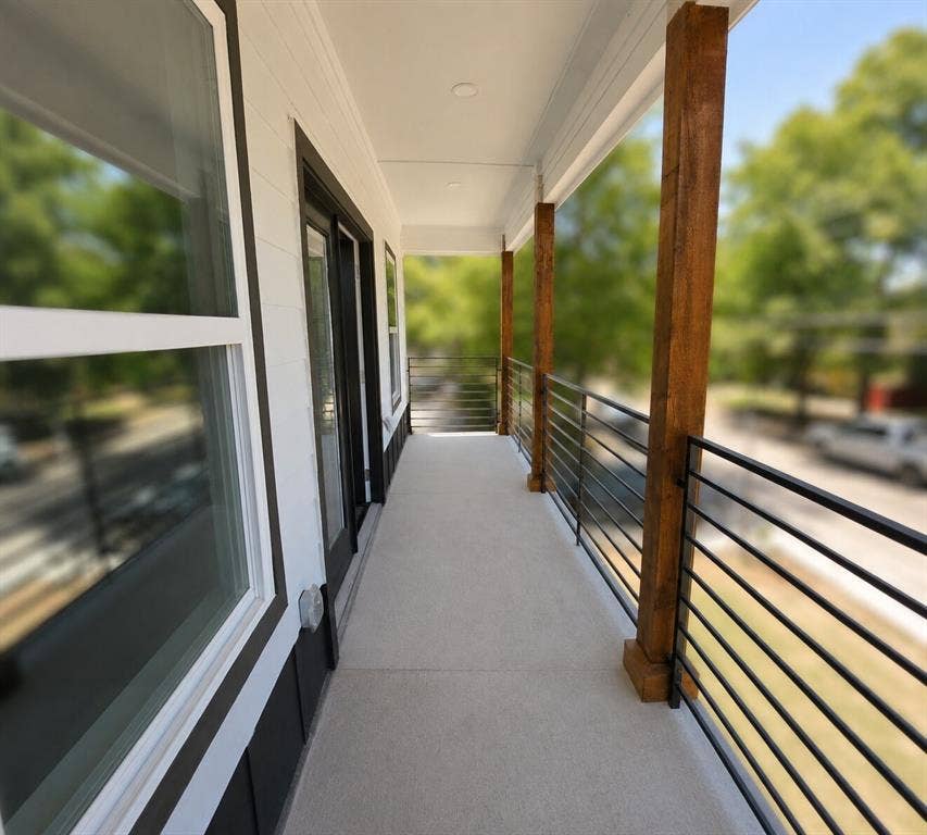 2542 Hooper Street, Dallas, TX 75215 Exterior balcony featuring a concrete floor, horizontal rod railing, and natural wood support columns