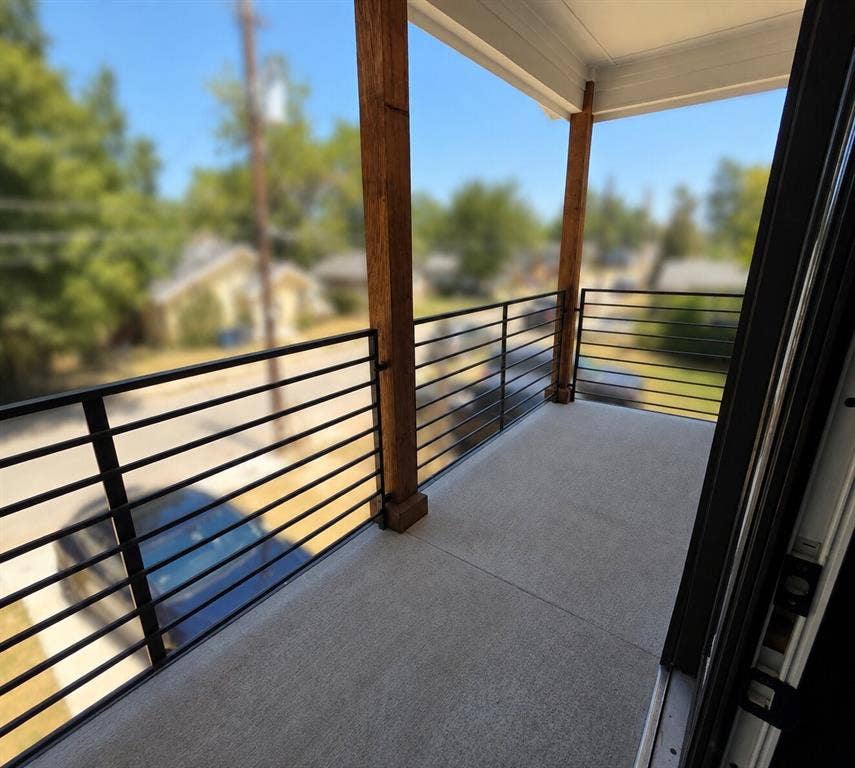 2542 Hooper Street, Dallas, TX 75215 Balcony with exposed wood structural beams, concrete flooring, and horizontal metal railings