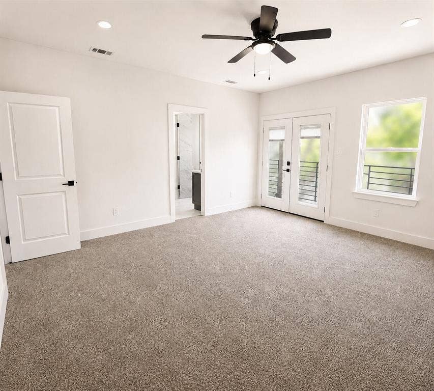 2542 Hooper Street, Dallas, TX 75215 Plush carpeting, ceiling fan with integrated lighting, white double French doors, large window with iron railing, and recessed lighting