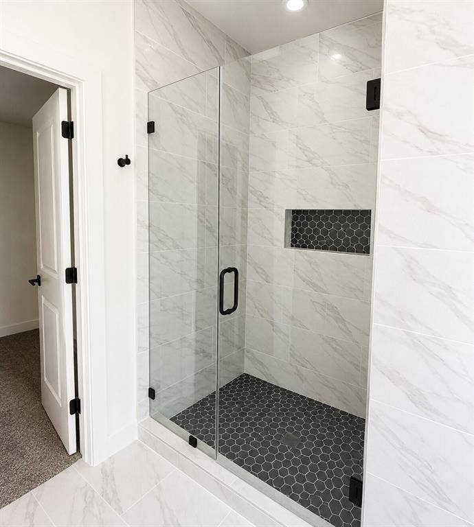 2542 Hooper Street, Dallas, TX 75215 Glass-enclosed shower with a black hexagonal tile floor, a recessed niche with hexagonal tile, and large format white tile walls