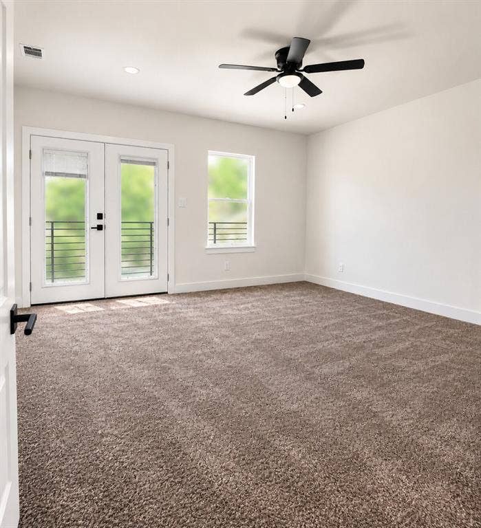 2542 Hooper Street, Dallas, TX 75215 Spacious room featuring neutral carpeting, double glass-paned doors with black hardware, a ceiling fan, and recessed lighting