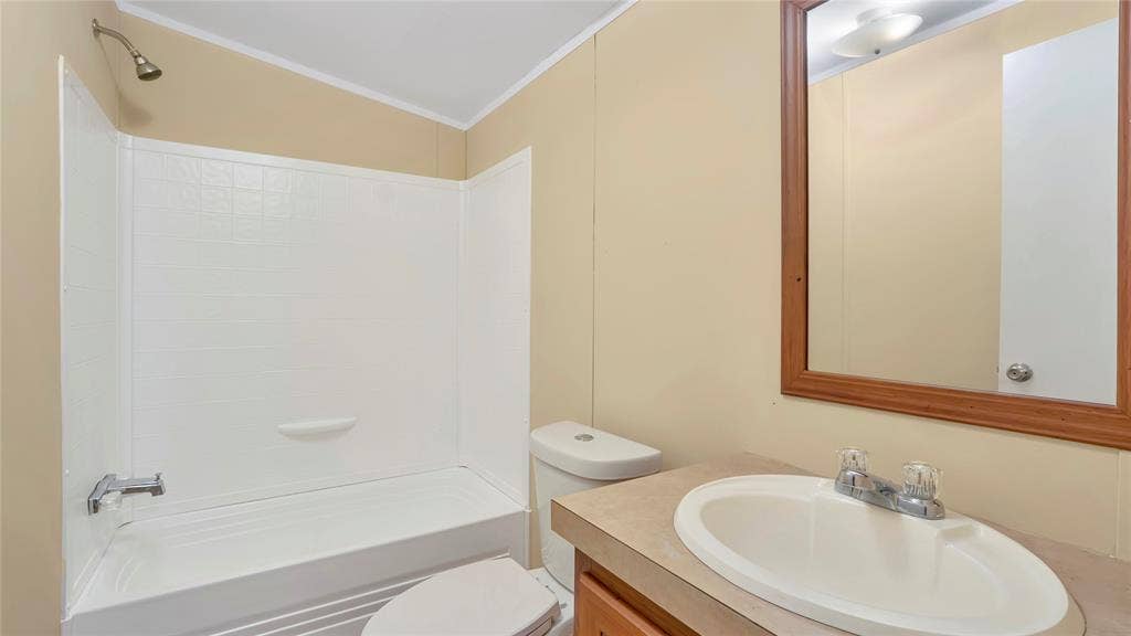5390 Fm 314 S, Larue, TX 75770 White bathtub with shower, toilet, vanity with integrated sink, and wood-framed mirror