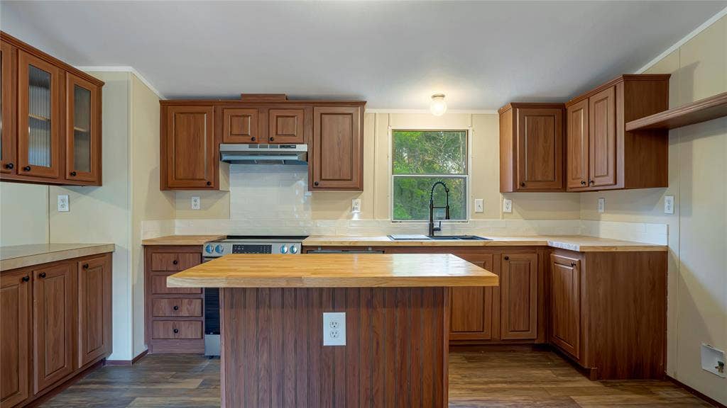 5390 Fm 314 S, Larue, TX 75770 Wood-finish flooring, wood cabinetry, built-in stainless steel appliances, central island with wood countertop, and a single basin sink with a black faucet