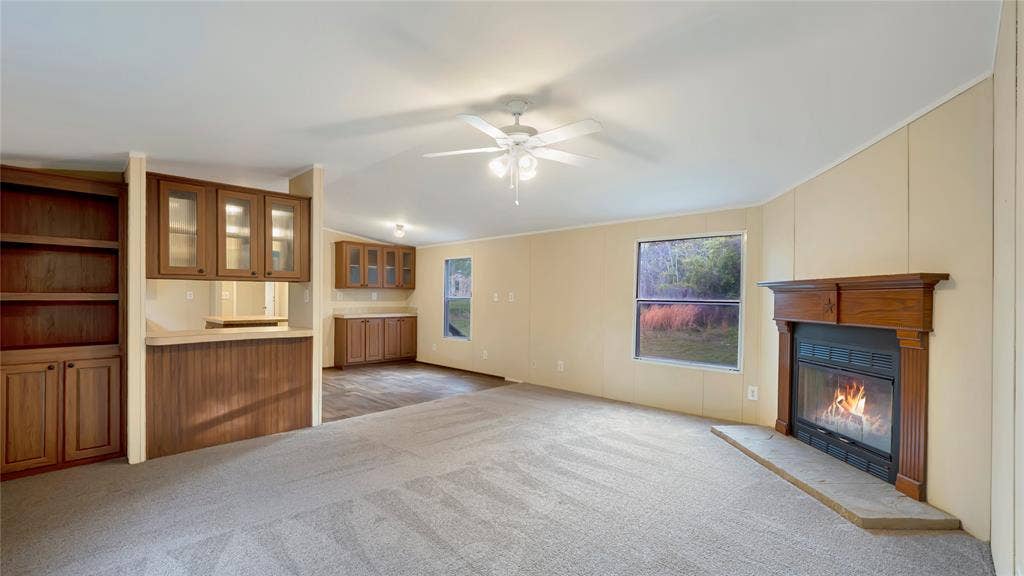 5390 Fm 314 S, Larue, TX 75770 Carpeted living area with built-in cabinetry, an integrated bar area, and a fireplace with a wood mantel