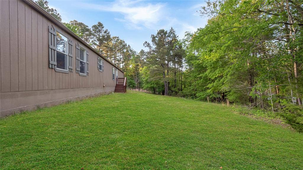 5390 Fm 314 S, Larue, TX 75770 Expansive grounds featuring a manicured lawn with mature tree-lined borders and wooded backdrop