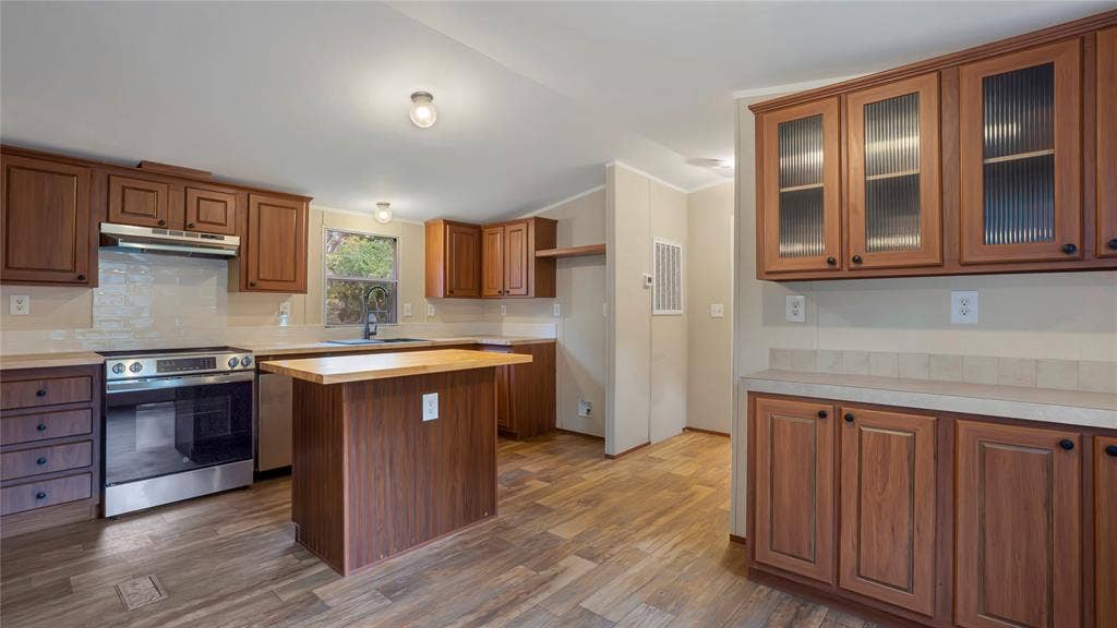 5390 Fm 314 S, Larue, TX 75770 Kitchen featuring wood-finish flooring, stainless steel appliances, a center island with a wood-finish countertop, and rich wood cabinetry with integrated lighting