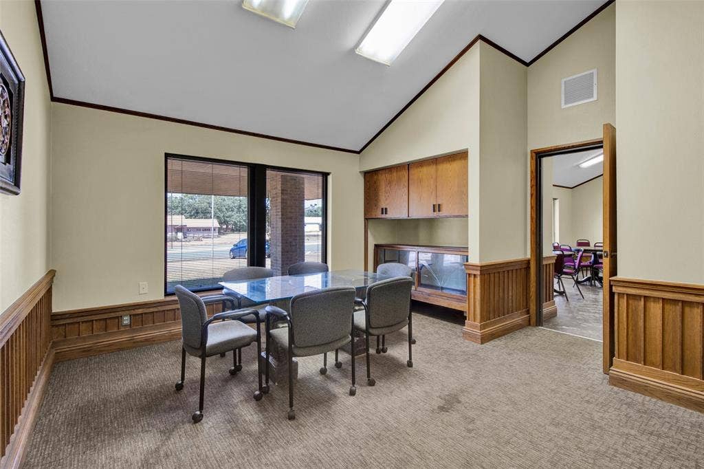 3210 W Northwest Loop 323, Tyler, TX 75702 Vaulted ceiling, wood paneling, built-in cabinetry, large window, and carpeted flooring