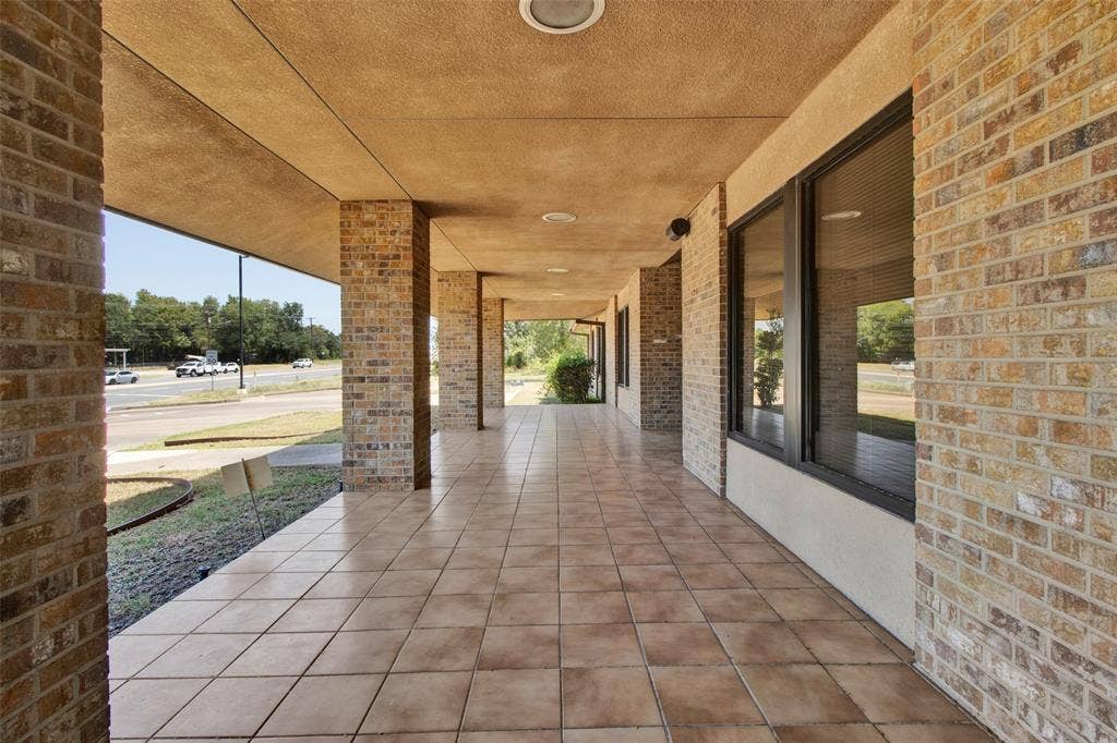 3210 W Northwest Loop 323, Tyler, TX 75702 Brick exterior with a covered walkway, tiled flooring, recessed lighting, and large window openings