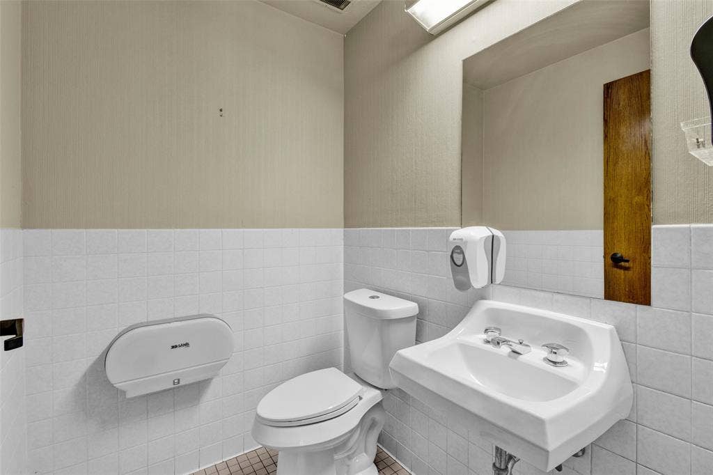 3210 W Northwest Loop 323, Tyler, TX 75702 White tiled wall extending to mid-height, wall-mounted sink, and a commode