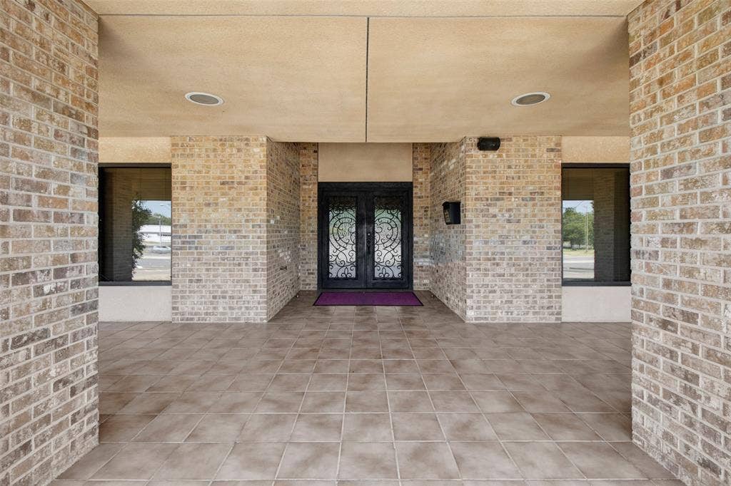 3210 W Northwest Loop 323, Tyler, TX 75702 Brick exterior with a covered entry, tile flooring, and double entry doors with decorative glass inserts